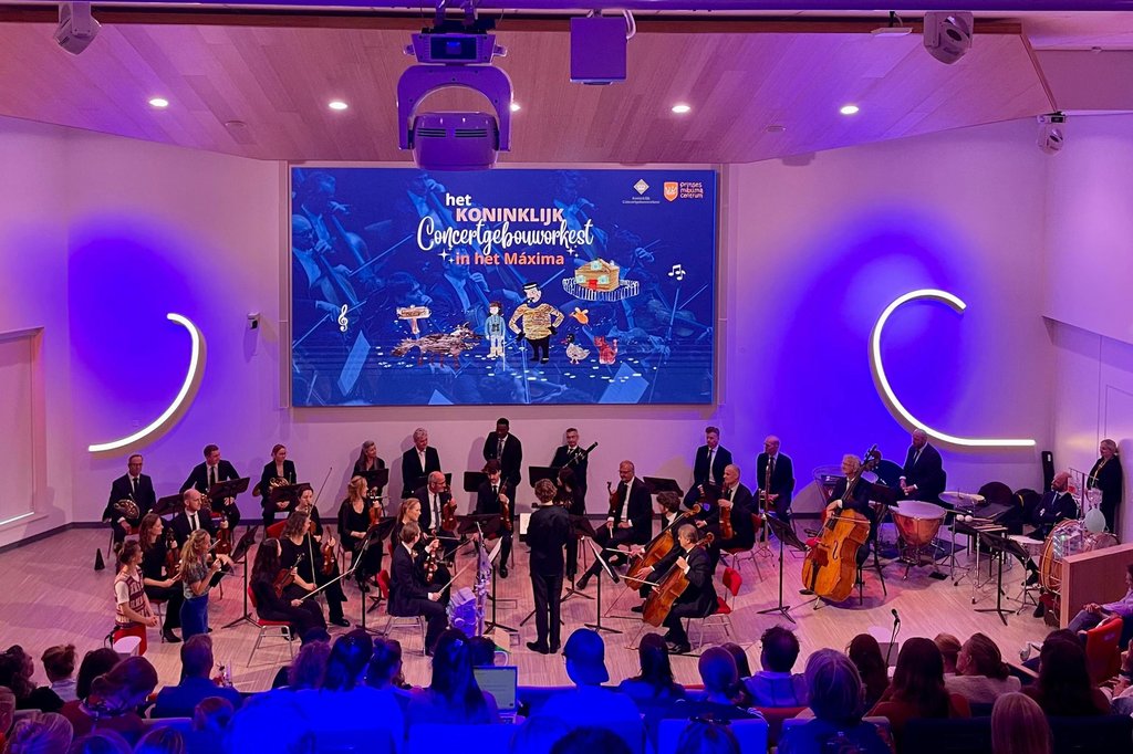 Het orkest speelt in het auditorium van het Prinses Maxima Centrum voor patiënten en medewerkers